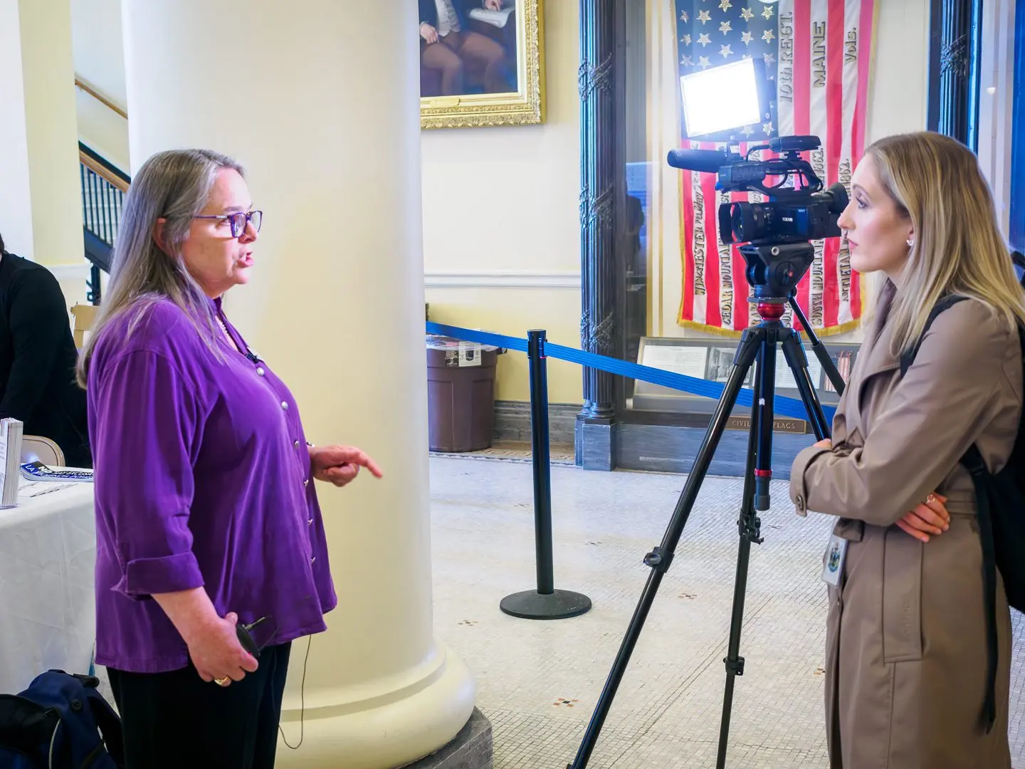 Francine Garland Stark being interviewed by a reporter at the Maine State House