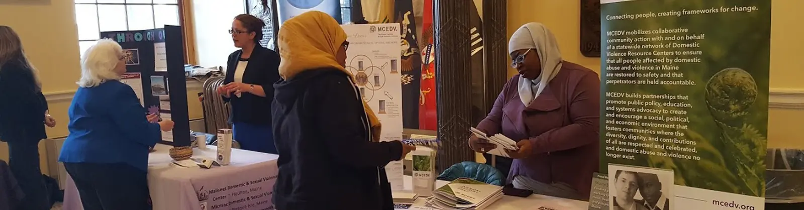 Advocates talking with visitors at an MCEDV information table