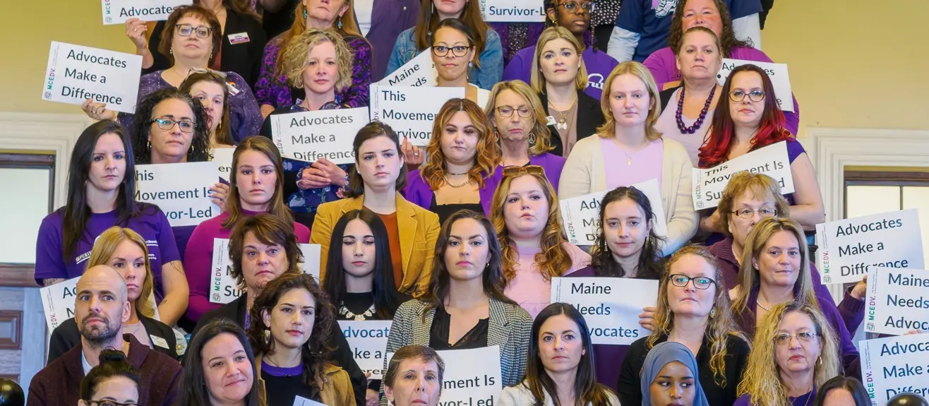 Advocates holding signs that read Advocates Make a Difference and This Movement Is Survivor-Led
